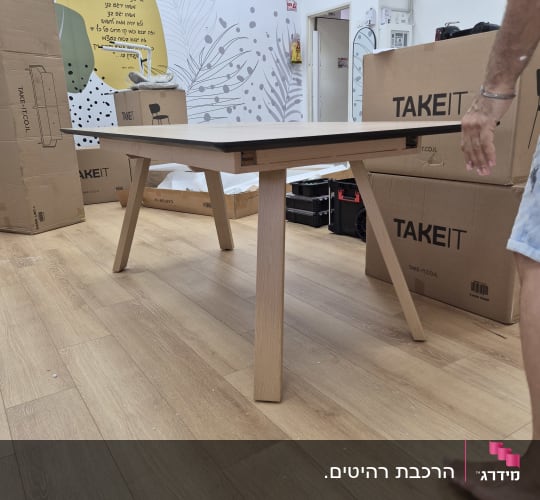 שולחן עץ בחדר עם קופסאות קרטון